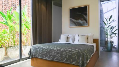 a bedroom with a bed and a large window at Teras by Tamora in Badung