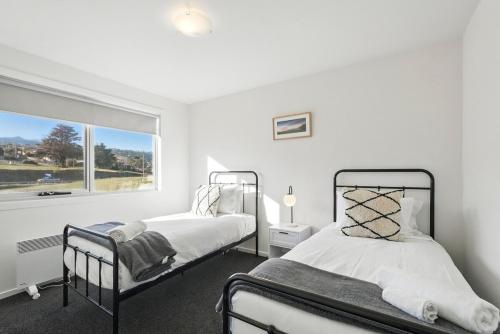 - 2 lits dans une chambre blanche avec fenêtre dans l'établissement Spacious Modern Home, à Lindisfarne