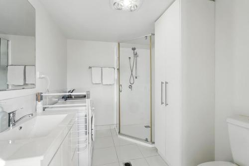 une salle de bain blanche avec une douche et un lavabo dans l'établissement Spacious Modern Home, à Lindisfarne