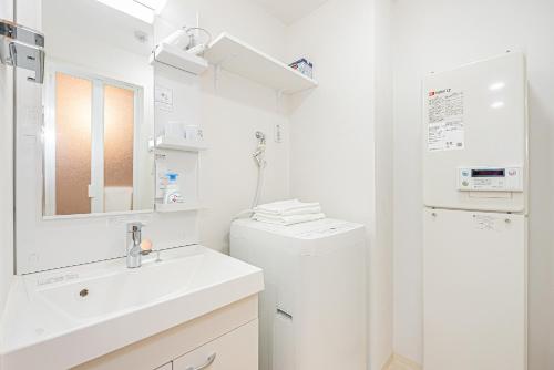 a white bathroom with a sink and a toilet at タスキスマート池袋一号館Tasuki Smart Ikebukuro1 in Tokyo