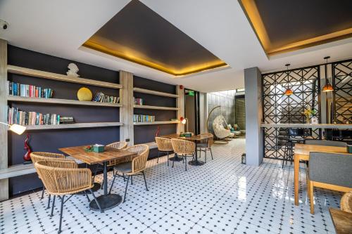 a dining room with tables and chairs and bookshelves at Antiya Hotel Phuket in Phuket Town