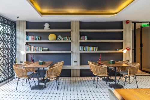 a room with two tables and chairs and bookshelves at Antiya Hotel Phuket in Phuket Town