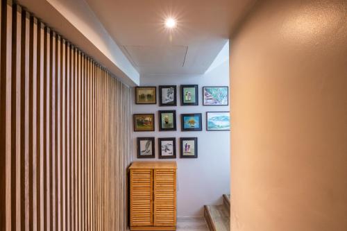 a hallway with a wall of framed pictures at Antiya Hotel Phuket in Phuket Town