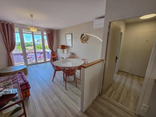 une cuisine et un salon avec une table et des chaises dans l'établissement L'Heure Sud T3 T3 clim avec garage au centre-ville, à Hyères