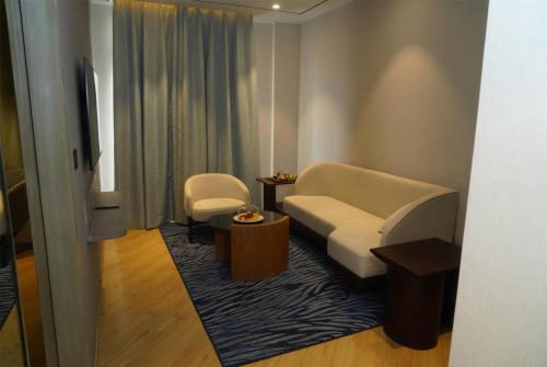a living room with a couch and two chairs at Ramada Encore by Wyndham Chandigarh Zirakpur in Zirakpur