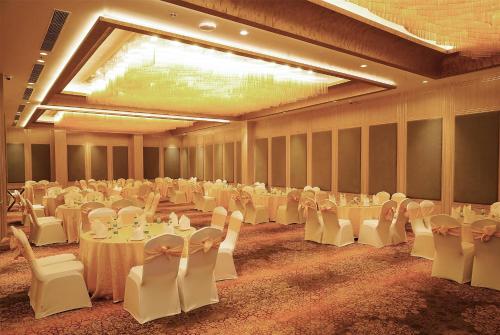 a large banquet hall with white tables and chairs at Ramada Encore by Wyndham Chandigarh Zirakpur in Zirakpur