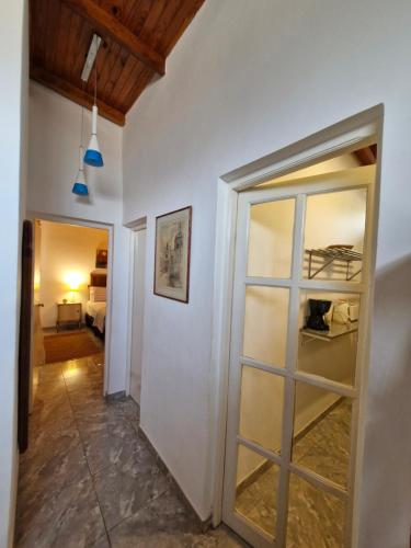 a hallway with a glass door and a bedroom at Bonpland departamentos in Puerto Iguazú