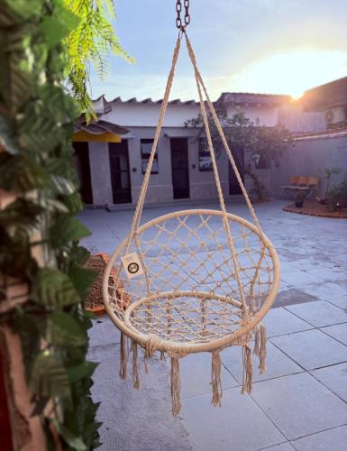a rope swing in a yard with a house at Pousada Lemon Suítes - Praia do Sesc Acesso Vista Linda e Centro in Bertioga