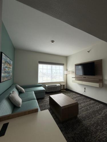 a living room with a couch and a flat screen tv at La Quinta by Wyndham Searcy in Searcy