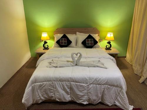 a bedroom with a large white bed with two lamps at DIAMOND Hotel and Resort in Dargai