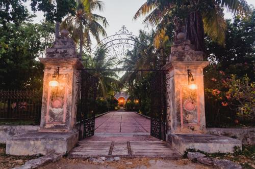 an entrance to a garden with an iron gate at Hacienda Sacnicte in Izamal