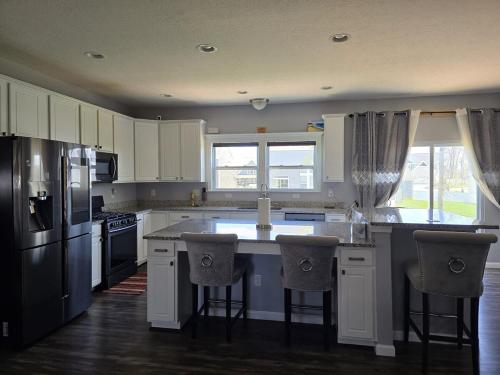 une cuisine avec des placards blancs et un grand îlot avec des tabourets de bar dans l'établissement Your Home Away from Home, à Marysville