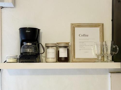 a shelf with a coffee maker and glasses on it at Dpto Costanera Gualeguaychu Alem in Gualeguaychú