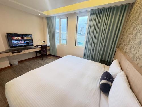 a hotel room with a bed and a television at Tc慢旅花蓮館-近東大門夜市市中心 in Hualien City