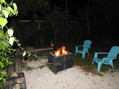 two chairs and a fire pit in a backyard at night at Casa Mares in Lepanto