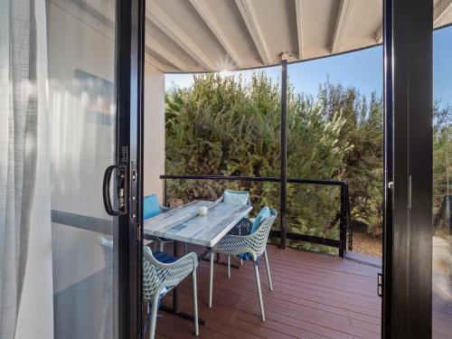 a patio with a table and chairs on a deck at A Beachy Place - Gnarabup in Gnarabup