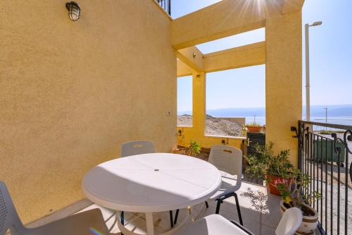 a patio with a white table and chairs on a balcony at זוהר במדבר ים המלח in Neve Zohar