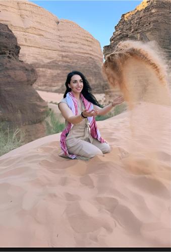 a woman sitting in the sand in the desert at Star Wars luxury camp in Wadi Rum