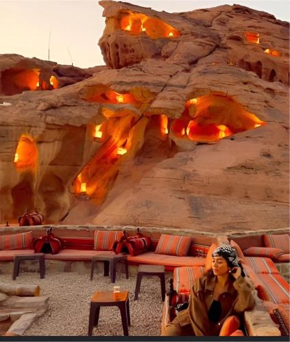 a woman sitting on a couch in front of a rock wall at Star Wars luxury camp in Wadi Rum