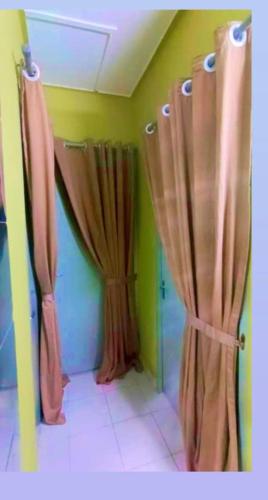 a bathroom with brown curtains in a room at HOMESTAY Rezeki in Batu Gajah
