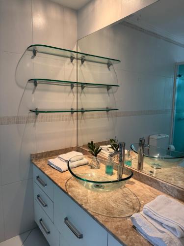 a bathroom with a counter with a sink and a mirror at Charmosa Casa em bairro nobre de Curitiba in Curitiba
