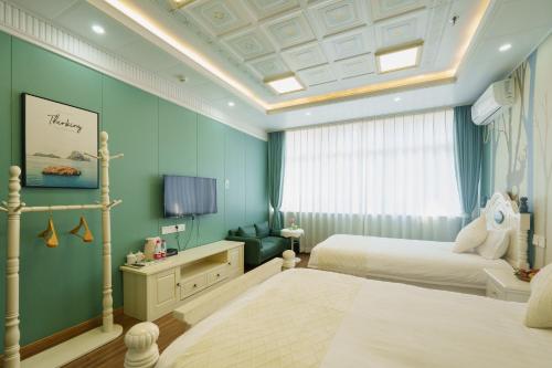 a bedroom with two beds and a tv in it at Floral Yilanxuan Zhouzhuang Hotel in Suzhou