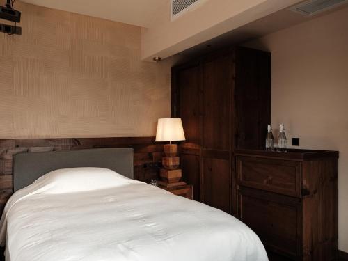 a bedroom with a white bed and a lamp at 丽江古城天德一品酒店 Lijiang Ancient Town TianDe Grande Hotel in Lijiang