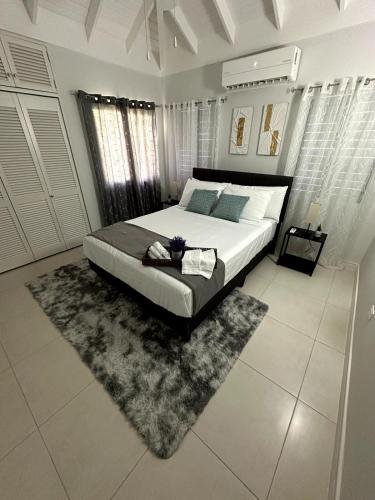a bedroom with a large bed and a rug at The Sunshine 3 Bedroom Villa with pool & gym in Richmond