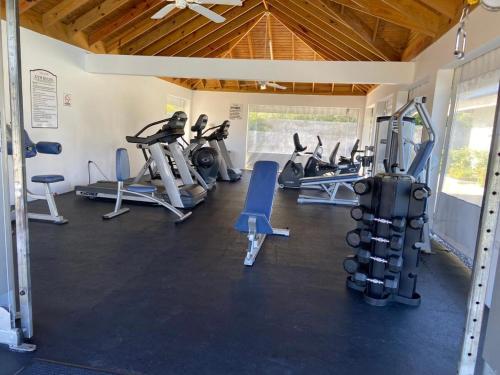 a gym with several treadmills and exercise bikes at The Sunshine 3 Bedroom Villa with pool & gym in Richmond