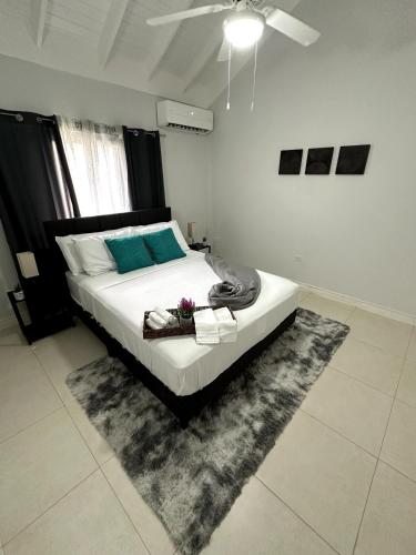 a bedroom with a bed with a rug and a ceiling fan at The Sunshine 3 Bedroom Villa with pool & gym in Richmond