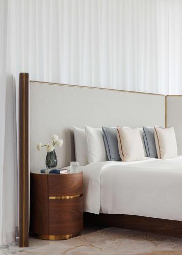 a bedroom with a bed and a table with a vase of flowers at One&Only One Za'abeel in Dubai