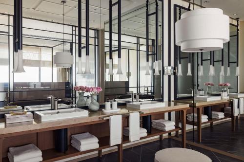 a bathroom with three sinks and mirrors with flowers at One&Only One Za'abeel in Dubai