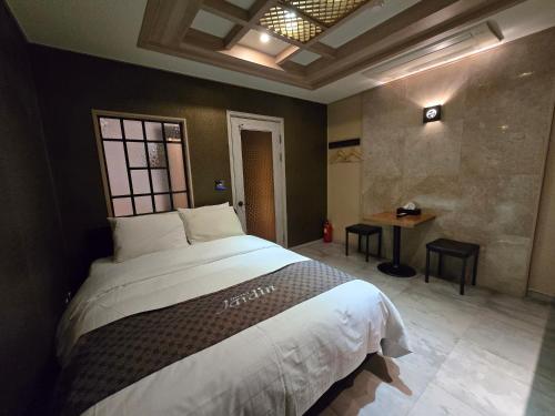 a bedroom with a large bed and a table at Jardin Hotel in Seoul