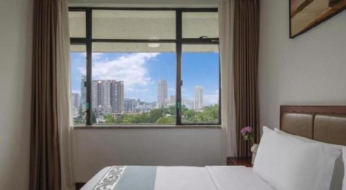 Un dormitorio con una ventana con vista a una ciudad. en Nanhai Oil Hotel, en Zhuhai