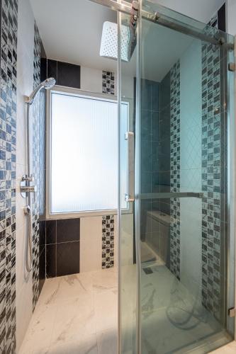 a shower with a glass door in a bathroom at Royal Prince Resort Pattaya in Pattaya South