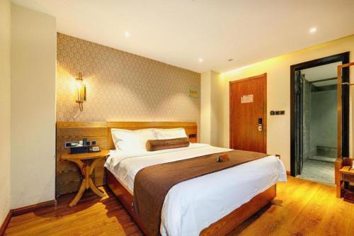a bedroom with a large bed and a desk at James Joyce Coffetel Qufu Tourist Center Gulou Street Sankong Scenic Spot in Jining