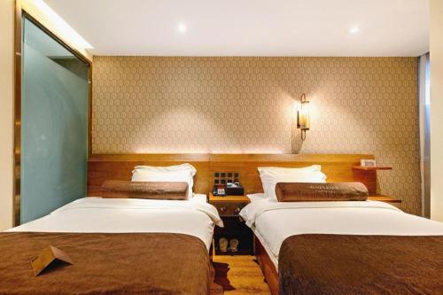 a room with two beds in a hotel room at James Joyce Coffetel Qufu Tourist Center Gulou Street Sankong Scenic Spot in Jining