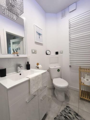 a white bathroom with a toilet and a sink at Neo Retro in Jelenia Góra
