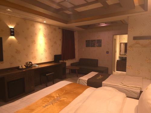 a hotel room with two beds and a desk at Jardin Hotel in Seoul