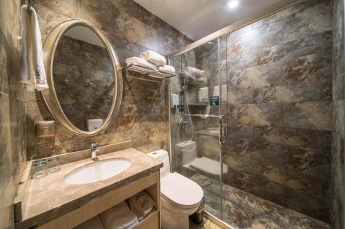a bathroom with a toilet and a sink and a shower at Leisurely Hotel Shenzhen in Shenzhen
