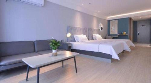 a hotel room with a large bed and a couch at Magnotel Hotel Jining Yanzhou Metro Station Jiuxianqiao South Road in Jining