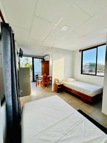 Un dormitorio con 2 camas y una mesa con mesa. en CASA FAMILIAR con vista BAHIA Y TERRAZA, en Puerto Ayora