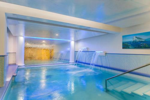 una piscina cubierta con una fuente de agua en Hotel La Madonnina en Isquia