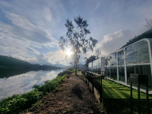 a train on a track next to a river at Epel Bintang tepi danau in Kejajar