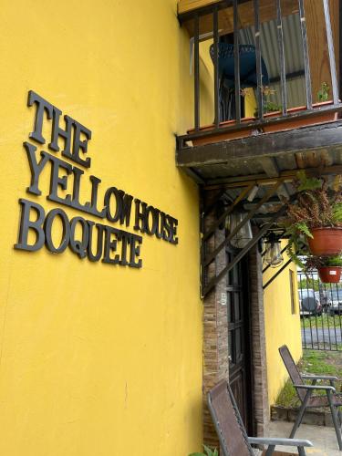 a yellow building with a yellow house with a balcony at The Yellow House Boquete hostal in Alto Boquete