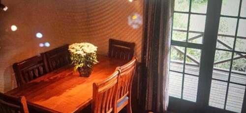 a wooden table with a vase of flowers on it at Rough Meadows - MTB Haven & Good Vibes Retreat in Rotorua