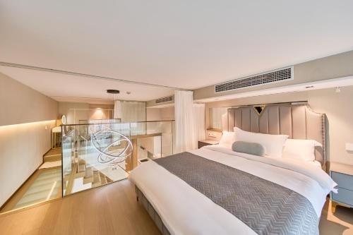 ein Schlafzimmer mit einem großen Bett und einem Glasbalkon in der Unterkunft Yifang Apartment in Hangzhou