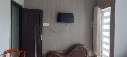 a room with a television on a wall with a chair at Motel ANA in Cái Răng