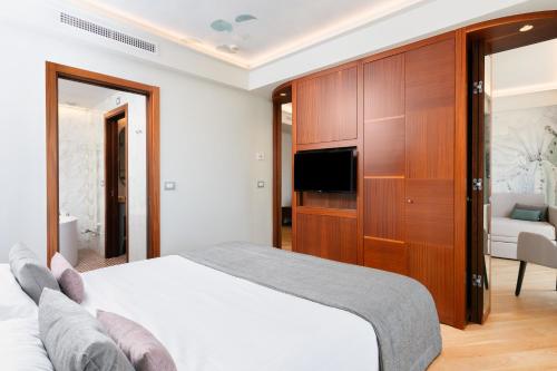 a bedroom with a bed and a tv and a cabinet at Best Western Hotel Nazionale in Sanremo