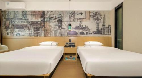 two beds in a room with a drawing on the wall at City Comfort Inn Beiliu Yongfeng Plaza Chengnan Bus Station in Yulin